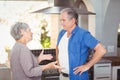 Side view of senior couple arguing in kitchen