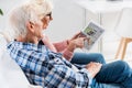 side view of senior couple using digital tablet with ebay
