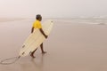Senior male surfer walking with surfboard on the beach Royalty Free Stock Photo