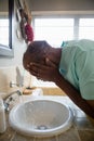 Side view of senior man washing his face at sink Royalty Free Stock Photo