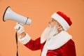 Side view of senior Santa Claus talking with megaphone