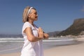 Side view of senior woman meditating in prayer position at beach Royalty Free Stock Photo