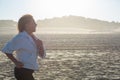 Side view of senior woman running on sandy beach in summer Royalty Free Stock Photo