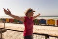 Senior woman standing with arms outstretched on a promenade at beach Royalty Free Stock Photo