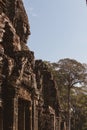 Side view of a serene carved face of Bayon against a blue cloudy sky at Angkor Wat