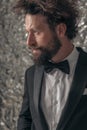 Side view of sexy bearded groom in black tuxedo looking to side Royalty Free Stock Photo