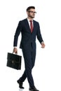 Businessman walking with briefcase on hand looking ahead serious Royalty Free Stock Photo