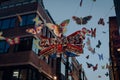 Side view of Shimmering Carnaby sign surrounded by butterflies on Carnaby Street, London, UK