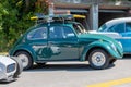 Side view of shiny turquoise Volkswagen Beetle with rack and surfboard on display at a car show Royalty Free Stock Photo