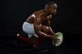 Side view shirtless man holding rugby ball