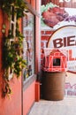 Side view of a shop display with red walls and a trash bin shaped as a lovely red colonial house in Vila GermÃÂ¢nica, Blumenau -
