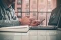 Side view shot of a man`s hands using smart phone in interior, rear view of business man hands busy using cell phone at office des Royalty Free Stock Photo