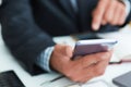 Top view shot of a man`s hands in suit using smart phone in office interior, business man hands using cell phone at Royalty Free Stock Photo