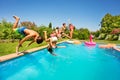 Happy friends doing front flip in swimming pool Royalty Free Stock Photo