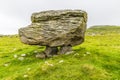 A side view showing a glacial erratic supported on the limestone pavement on the southern slopes of Ingleborough, Yorkshire, UK Royalty Free Stock Photo