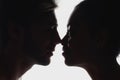 side view of silhouettes of interracial couple in love looking