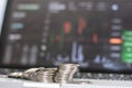 Side view of silver coin with monitor shows trading traffic, Bitcoin minning