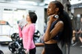 Side view of slim black african-american fitness instructor and asian lovely woman doing fitness exercise work with Royalty Free Stock Photo