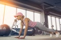 Side view of a slim fitnes young blonde girl doing planking exer