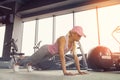 Side view of a slim fitnes young blonde girl doing planking exercise at gym
