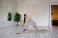 Pretty positive young brunette woman doing Utthita parsvakonasana exercise, yoga and pilates Royalty Free Stock Photo