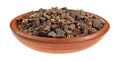 Side view of a small bowl of cocoa nibs on a white background