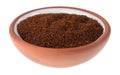 Side view of a small terracotta spice bowl filled with chili powder isolated on a white background