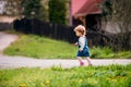 Side view of small toddler girl walking in the countryside in spring.