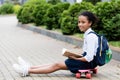 Smiling african american schoolgirl reading book Royalty Free Stock Photo