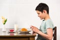 View of smiling boy using digital tablet during breakfast in kitchen Royalty Free Stock Photo