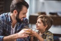 side view of smiling father and son clinking glasses of juice during breakfast