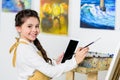 side view of smiling kid painting and using tablet in workshop of Royalty Free Stock Photo