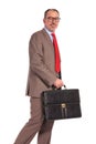 Side view of a smiling old businessman with briefcase walking Royalty Free Stock Photo