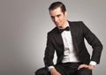 Side view of a smiling seated young man in tuxedo Royalty Free Stock Photo