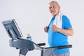 side view of smiling senior man with towel exercising on treadmill Royalty Free Stock Photo