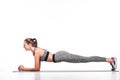 side view of smiling sportswoman doing plank exercise on yoga mat Royalty Free Stock Photo