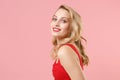 Side view of smiling young blonde woman girl in red sexy clothes posing isolated on pastel pink wall background studio Royalty Free Stock Photo