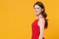 Side view of smiling young brunette woman girl in red summer dress posing isolated on yellow background studio portrait Royalty Free Stock Photo