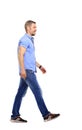 side view of a smiling young casual man walking , on white backg Royalty Free Stock Photo