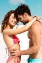 View of smiling young couple embracing together on sandy beach Royalty Free Stock Photo