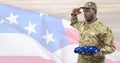 Side view of soldier holding an american flag in front of american background Royalty Free Stock Photo