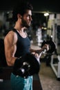 Side view of sportive bearded young man with muscular body working out with barbell Royalty Free Stock Photo