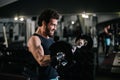 Side view of sportive bearded young man with muscular body working out with barbell Royalty Free Stock Photo