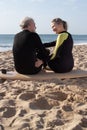 Side view of sporty mature couple on wooden surfboard