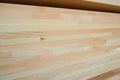 Side view of stack of three-layer wooden glued laminated timber beams from pine finger joint spliced boards