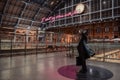 Side view of a statue of John Betjeman by Martin Jennings within interior of St. Pancras Station, London, UK