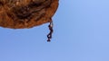 Side view of a stone man hanging from the rock above a shallow cave. The lone men are a mystery found in the northern Kaokoveld of