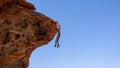 Side view of a stone man hanging from the rock above a shallow cave. The lone men are a mystery found in the northern Kaokoveld of