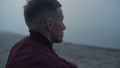 Stressed guy looking ocean landscape in morning. Worried man sitting on beach Royalty Free Stock Photo