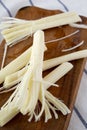 Side view, string cheese on rustic wooden board. Healthy snack.